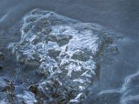 Kreuzförmige Eiskristalle auf vereistem Stein im Lochgrabenbach